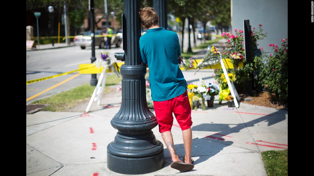A man leans against a light pole as he visits a memorial in Charleston on June 18.