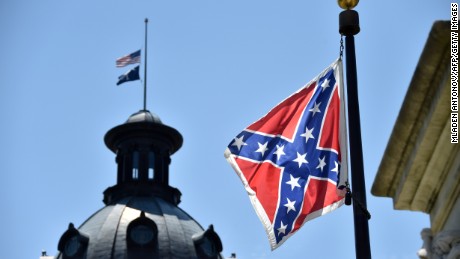 The South Carolina and American flags flying at half-staff behind the Confederate flag erected in front of the State Congress building in Columbia, South Carolina on June 19, 2015.