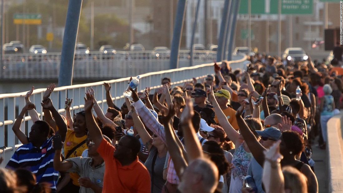 Thousands of people march on the Arthur Ravenel Jr. Bridge in Charleston, South Carolina, on Sunday, June 21.  People crossed the bridge, which spans the Cooper River, from Mount Pleasant to Charleston, joining hands in a unity chain to mourn the Emanuel AME Church shooting. Police arrested Dylann Storm Roof in the slayings of &lt;a href=&quot;http://www.cnn.com/2015/06/18/us/gallery/charleston-south-carolina-church-shooting/index.html&quot; target=&quot;_blank&quot;&gt;nine people &lt;/a&gt;at a prayer meeting at the church. 