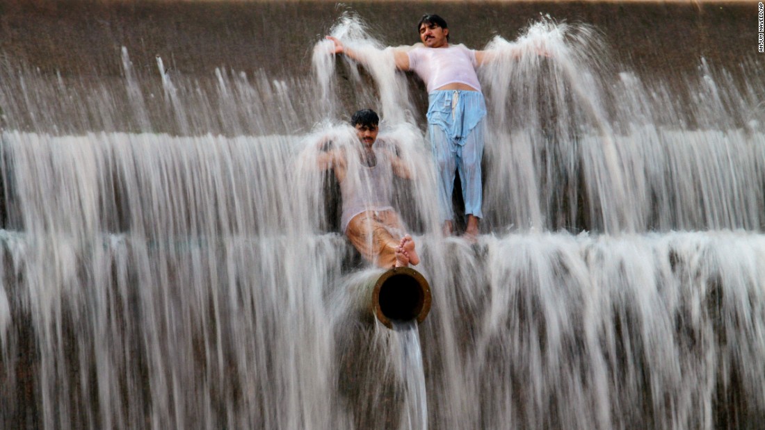 Pakistanis cool off at a river outside Islamabad on Sunday, June 21.