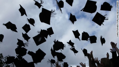 Students throw their caps in the air as they graduate