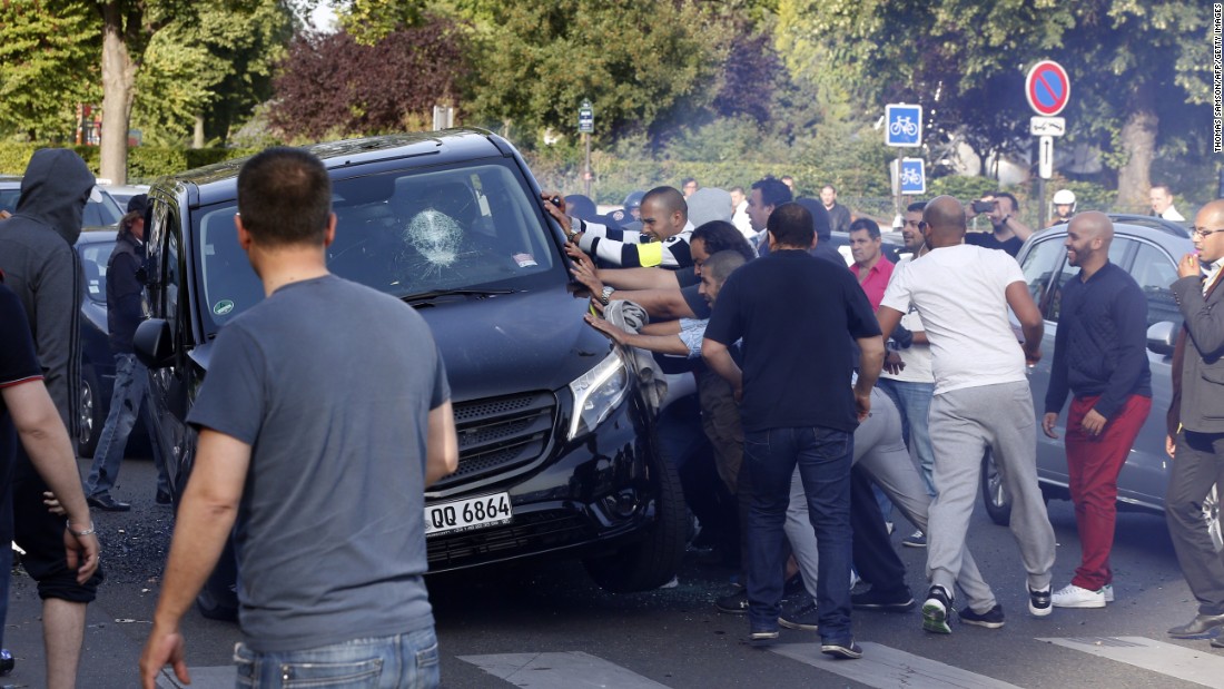 Demonstrators try to turn over a car at Porte Maillot in Paris on June 25.