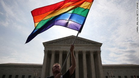 WASHINGTON, DC - JUNE 25: A gay marriage waves a flag in front of the Supreme Court Building June 25, 2015 in Washington, DC. The high court is expected rule in the next few days on whether states can prohibit same sex marriage, as 13 states currently do. (Photo by Mark Wilson/Getty Images)