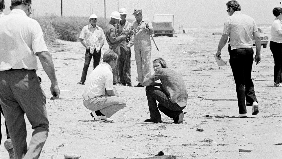 David Brooks, 18, right, squats on the beach with a law enforcement official as police search for bodies in High Island, Texas, in 1973. Brooks was implicated with Elmer Wayne Henley and Dean Corll, in the murders of at least 24 young men in a mass slaying case. &quot;Dean Corill would pick up kids, and once he had them in his house, he would incapacitate them and put them on what he called his &quot;death board&quot; and rape and kill them,&quot; according to Stephen G. Michaud, author of &quot;The Only Living Witness.&quot; Corll died in 1973.