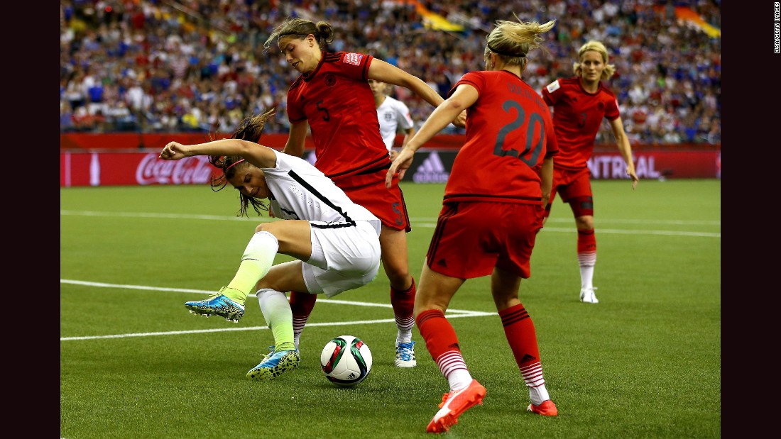 Alex Morgan of the United States is defended by Germany&#39;s Annike Krahn, left, and Lena Goessling.