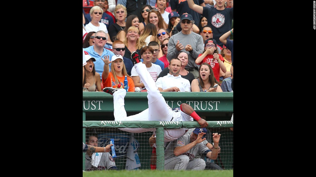 Boston&#39;s Pablo Sandoval falls into Houston&#39;s dugout while catching a ball Saturday, July 4, in Boston&#39;s Fenway Park.