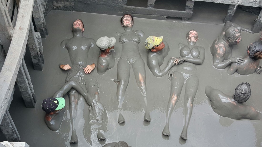 Once inside the volcano, attendants slather bathers in mud.