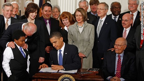 President Obama signs the Affordable Health Care for America Act during a ceremony with fellow Democrats in the White House. The law is an attempt to end the Age of Reagan, one writer says.
  