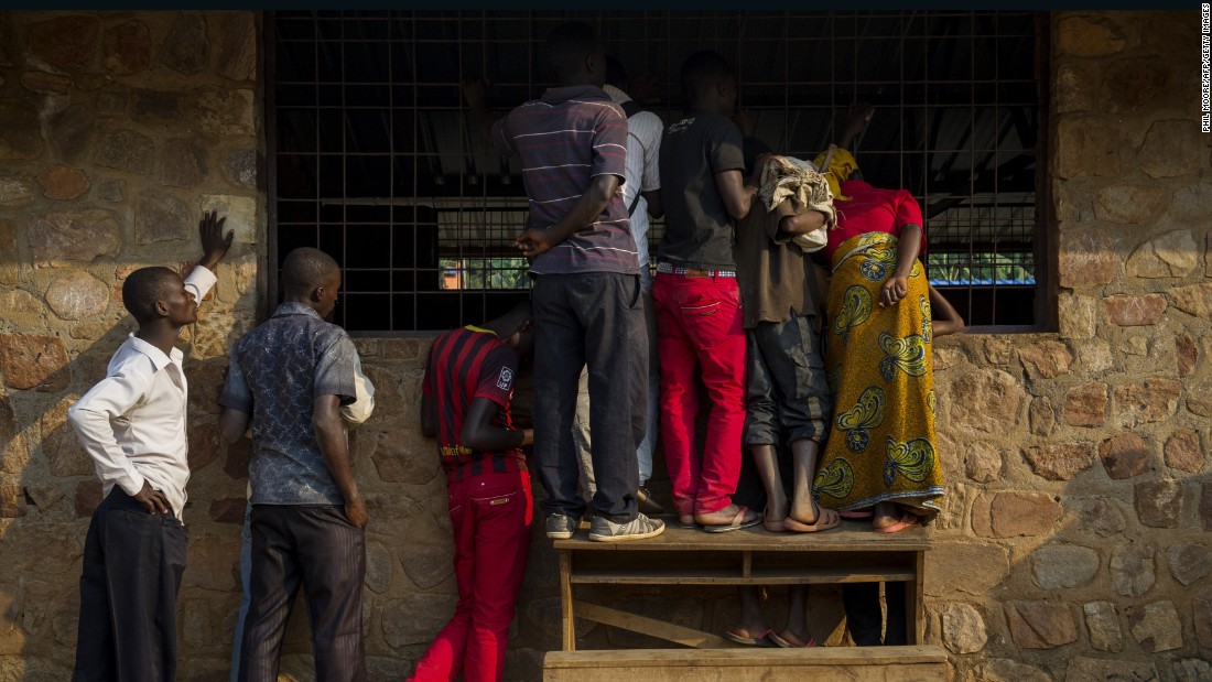 People watch through a window as voting officials count ballot papers in Mubimbi, Burundi, on July 21.