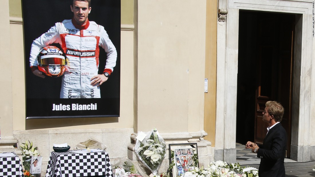 Mercedes driver Nico Rosberg pauses at the main entrance to the cathedral where tributes had been lain below a portrait of Jules Bianchi in his Marussia racing suit.
