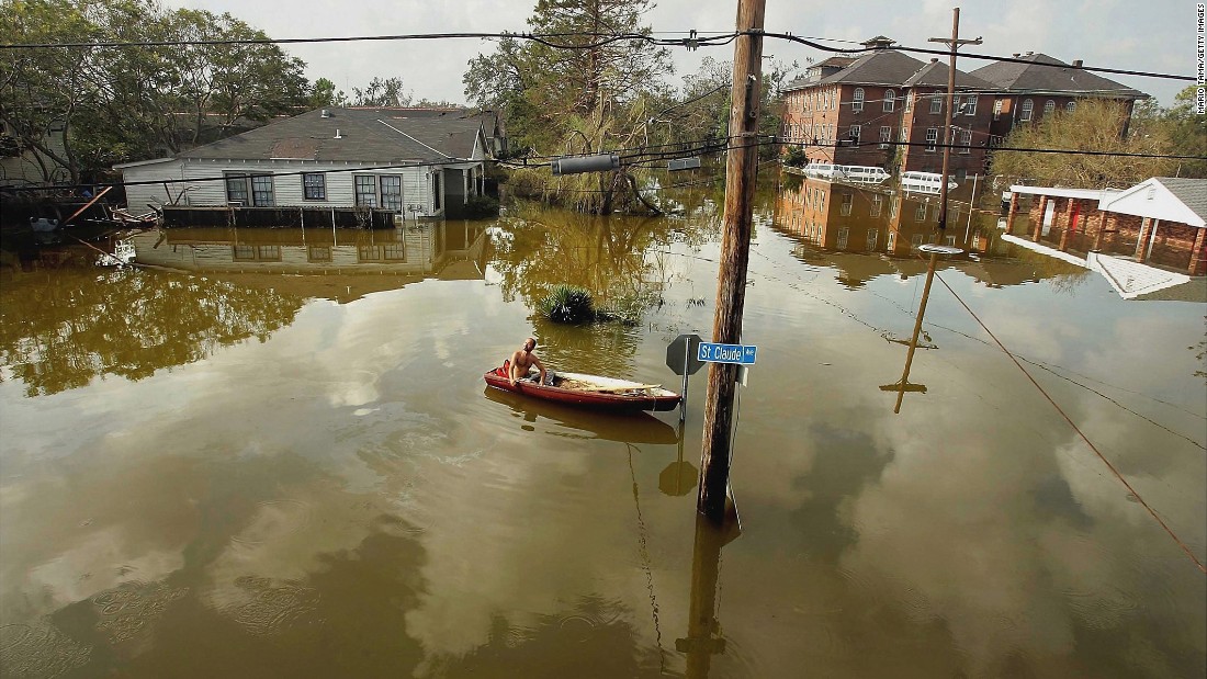 A man in New Orleans&#39; Lower Ninth Ward rides a canoe in high water on August 31, 2005. Hurricane Katrina struck the Gulf Coast on August 29, 2005. After levees and flood walls protecting New Orleans failed, much of the city was underwater. At least 1,833 died in the hurricane and subsequent floods. It was the costliest natural disaster in U.S. history.