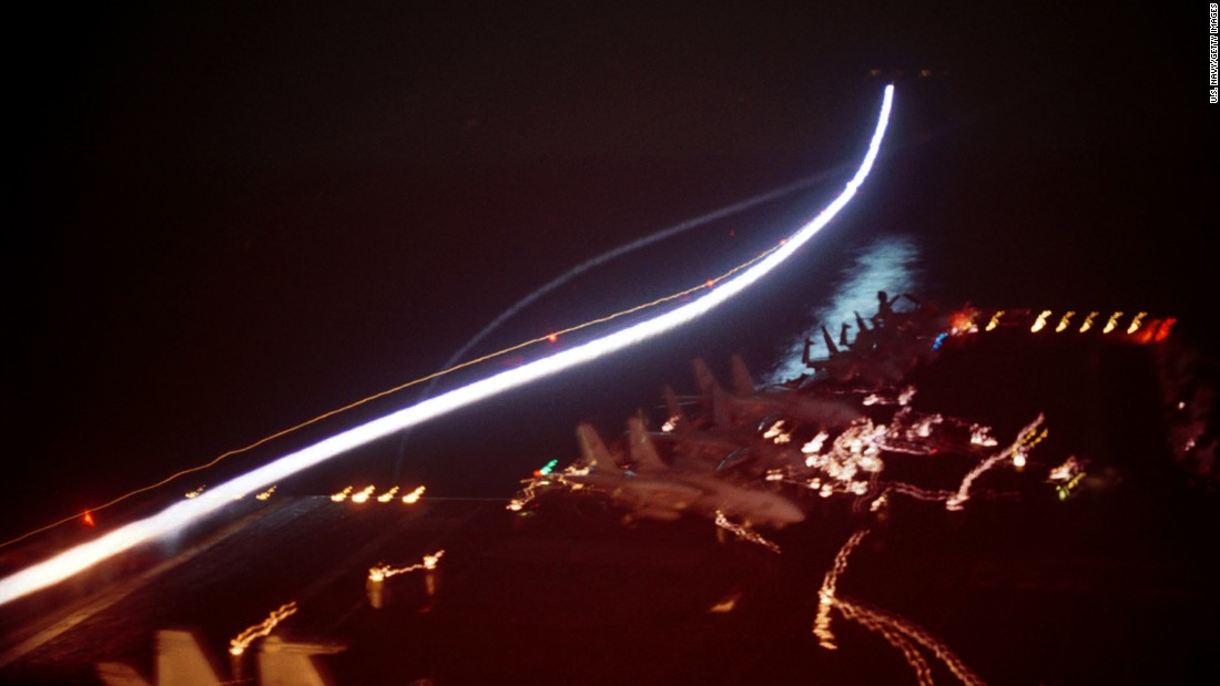 After the 9/11 attacks, the United States conducted military strikes against al Qaeda training camps and military installations of the Taliban regime. In this long-exposure photo, a U.S. Navy fighter jet takes off from the deck of the USS Enterprise on October 7, 2001. 