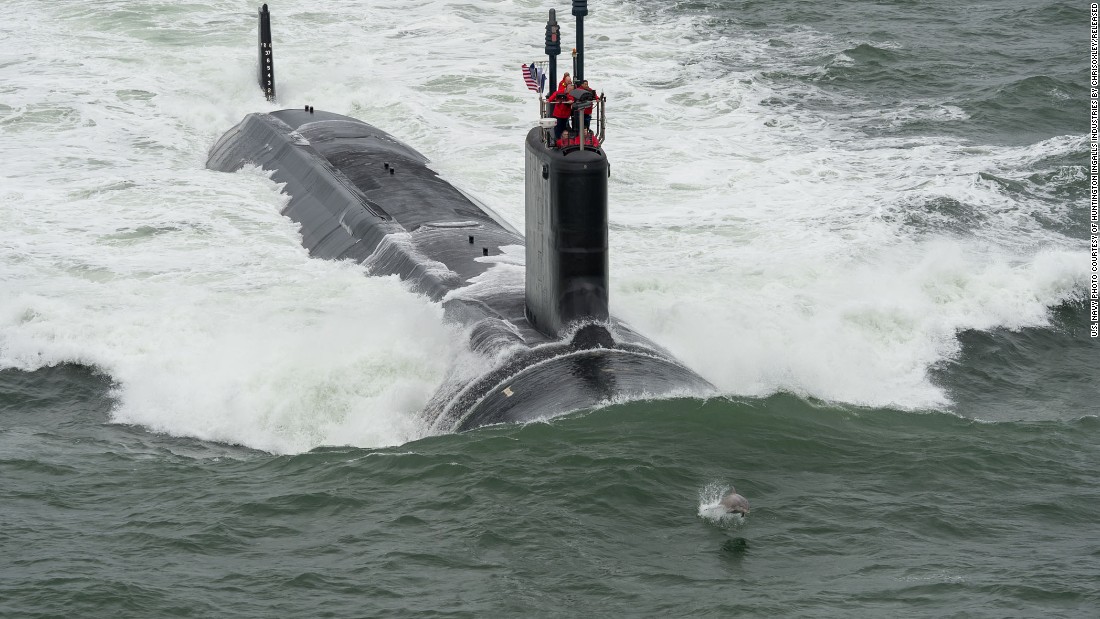 The request includes $5.2 billion to buy two Virginia-class attack submarines. Here, a dolphin swims in front of the USS John Warner during its sea trials in May.