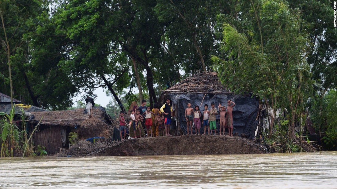 In Cox&#39;s Bazar, Bangladesh, villagers stood near a broken embankment to avoid floodwater after the area was hit by torrential rains from Cyclone Komen.