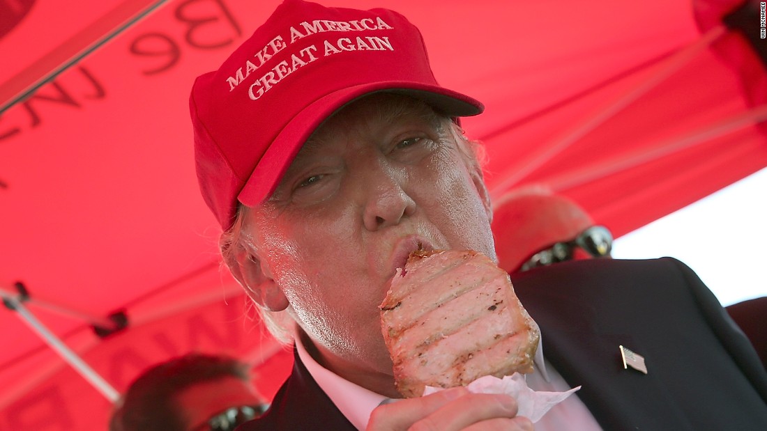 Trump eats a pork chop on a stick while attending the Iowa State Fair on August 15.
