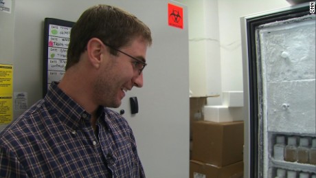 Eric, a poop donor for OpenBiome, looks at bottles of frozen fecal transplants he helped create. 