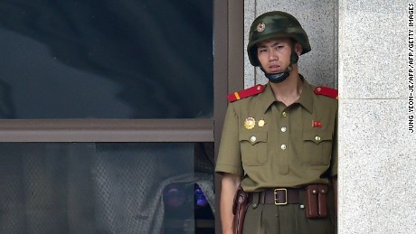 A North Korean soldier looks toward the South side while a group of foreign veterans who fought for South Korea during the 1950-53 Korean War and their relatives visit the truce village of Panmunjom in the Demilitarized Zone (DMZ) dividing the two Koreas on July 28, 2015. The veterans from Canada, the United States and Colombia were invited by a South Korean church group to mark the 62nd anniversary of the signing of an armistice accord that ended the war on July 27, 1953.      AFP PHOTO / JUNG YEON-JE        (Photo credit should read JUNG YEON-JE/AFP/Getty Images)