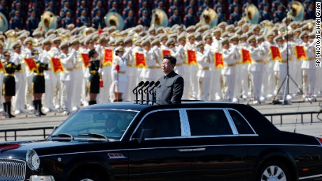 Xi stands in a car to review the army during a parade commemorating the 70th anniversary of Japan's surrender during World War II in Beijing in 2015.