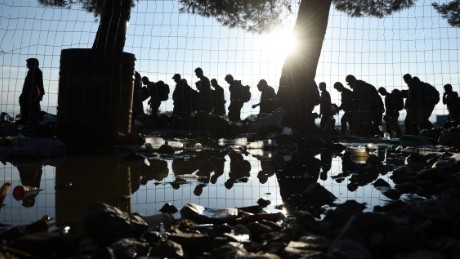 The sun rises as refugees and migrants walk to pass from the northern Greek village of Idomeni to southern Macedonia, Friday, Sept. 11, 2015. The sudden onset of autumn has taken tens of thousands by surprise all along the Balkans route from Greece to Hungary, the main gateway to Western Europe for more than 160,000 asylum seekers already this year. (AP Photo/Giannis Papanikos)