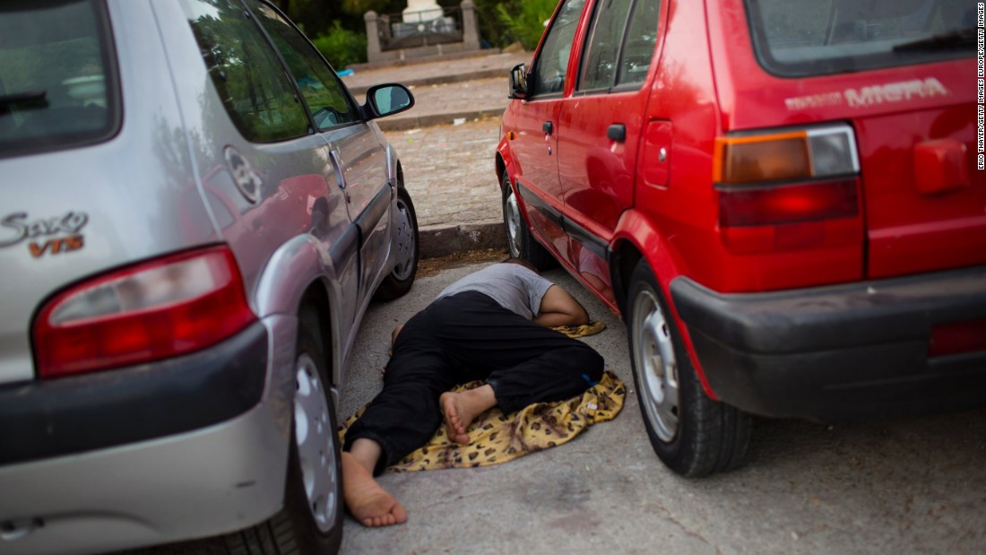 A refugee sleeps near the port of Mytilini on September 9, 2015 in Lesbos. He&#39;s one of thousands of migrants who have landed on the island&#39;s shores, after boarding inflatable boats from Turkey. 