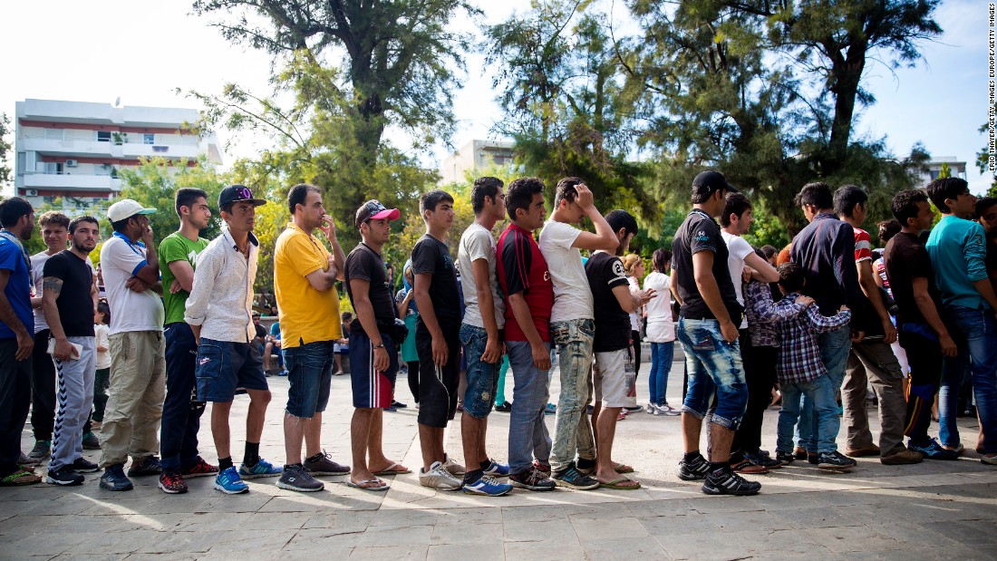 Long queues form as refugees wait to receive food in a park near the port of Mytilini, Lesbos. Many arrive wet, hungry and tired after paying huge amounts of money to risk their lives on small, crowded boats.