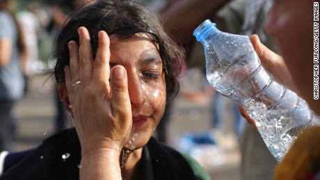 A migrant girl has stinging chemicals washed from her eyes Wednesday in Horgos, Serbia. 
