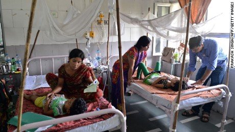 A doctor attends to dengue patients in a pediatric ward at New Delhi&#39;s Hindu Rao hospital. 