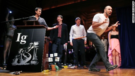Bruno Grossi, a researcher from Chile, shows how a chicken would walk like a dinosaur with a weighted stick attached to its tail, while being honored with an Ig Nobel Prize on Thursday, September 17, 2015. 