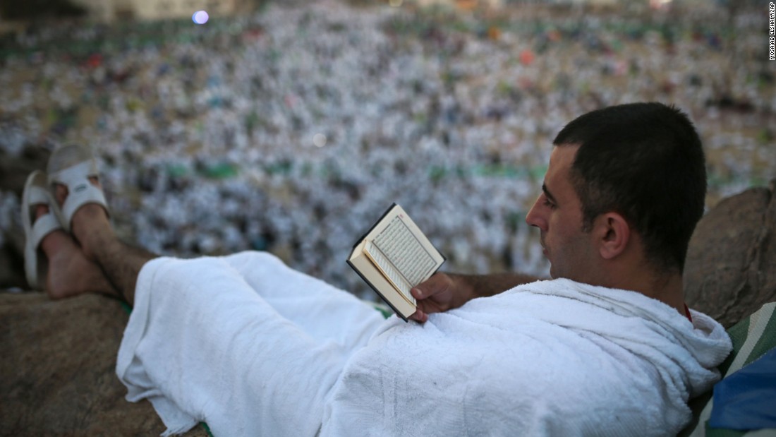 A pilgrim reads the Quran on a rocky hill called the Mountain of Mercy, on the plain of Arafat, near Mecca on Wednesday, September 23.