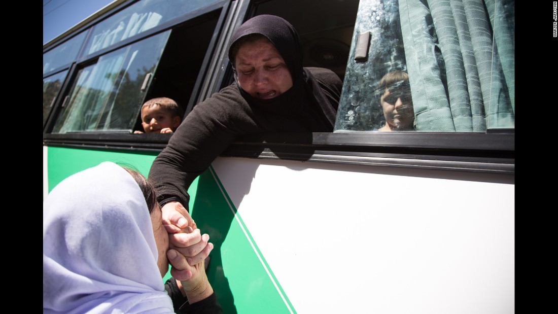 A Yazidi woman kisses the hand of a relative before a bus takes women and children who were captives of ISIS to an airport in the Kurdish region of Iraq. From there, they will fly to Germany, where the German government is resettling up to 1,000 former captives of ISIS, giving them housing and psychological treatment.