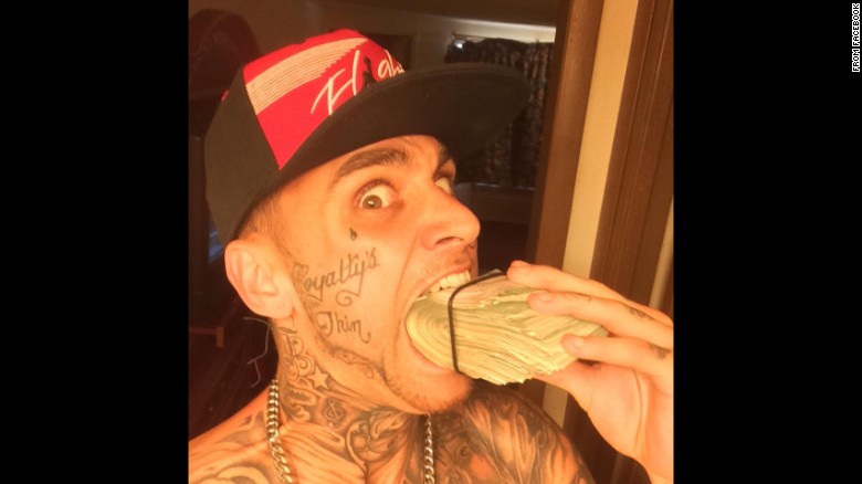 A photo posted to Facebook shows a man -- later accused in an Ohio bank robbery -- playfully chomping on a huge wad of cash.
