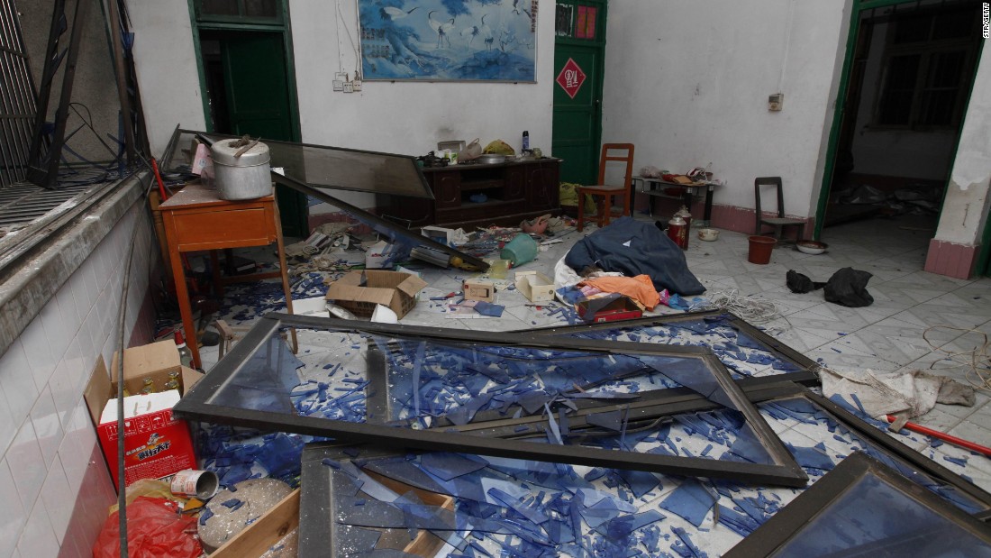 Damaged windows, debris and shattered glass are seen in a room that was hit by the explosion. 