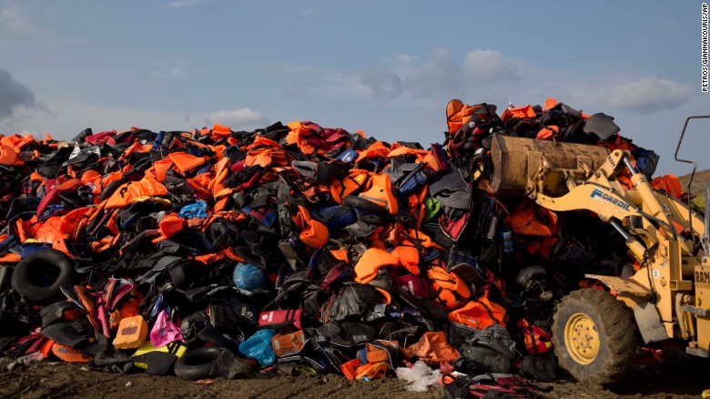 In September 2015, an excavator dumps life vests that were previously used by migrants on the Greek island of Lesbos.