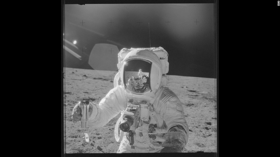 Astronaut Alan Bean holds a sample of lunar soil during Apollo 12. Pete Conrad&#39;s reflection can be seen in Bean&#39;s visor as he takes the photo.