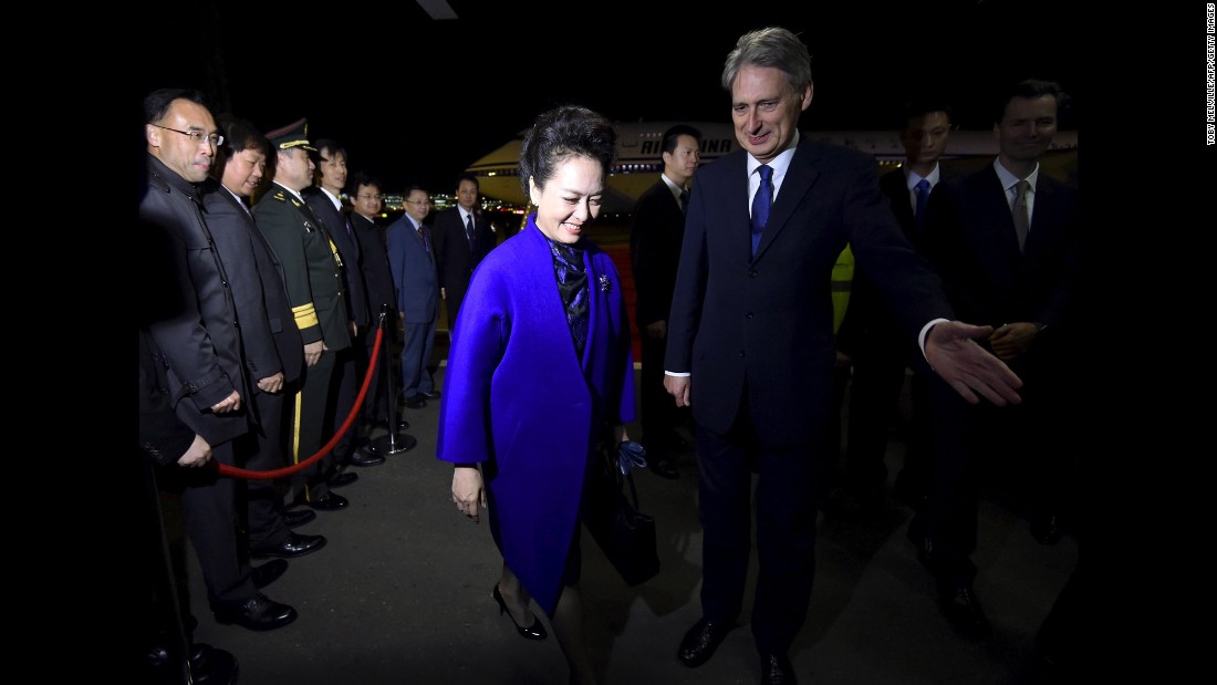 Hammond greets Peng after she arrived with her husband at Heathrow Airport.