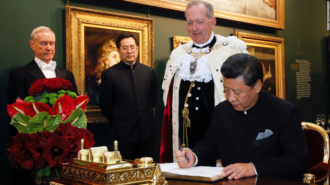 Xi signs the distinguished visitors book before a banquet at the Guildhall in London on Wednesday, October 21.