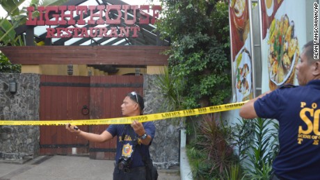 Police mark the crime scene with yellow tape where two Chinese diplomats were killed in Cebu, Philippines on Wednesday.