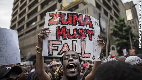 A student holds a placard reading &#39;A placard with &quot;Zuma must fall&quot; outside the Luthuli House, the ANC headquarters, on October 22, 2015, in Johannesburg, during a demonstration of thousands of students against university fee hikes.