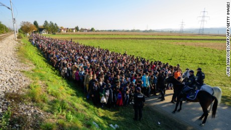 Police escort migrants toward a refugee center after crossing the Croatian-Slovenian border in 2015.