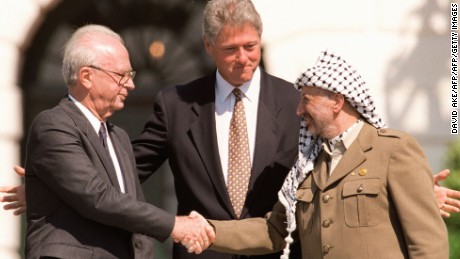 WASHINGTON, DC - SEPTEMBER 13:  US President Bill Clinton (C) stands between PLO leader Yasser Arafat (R) and Israeli Prime Minister Yitzahk Rabin (L) as they shake hands 13 September 1993 at the White House in Washington DC. Rabin and Arafat shook hands for the first time after Israel and the PLO signed a historic agreement on Palestinian autonomy in the occupied territories. Rabin was assassinated reportedly by a Jewish extremist 04 November 1995 after attending a peace rally in Tel Aviv.  (Photo credit should read J. DAVID AKE/AFP/Getty Images)