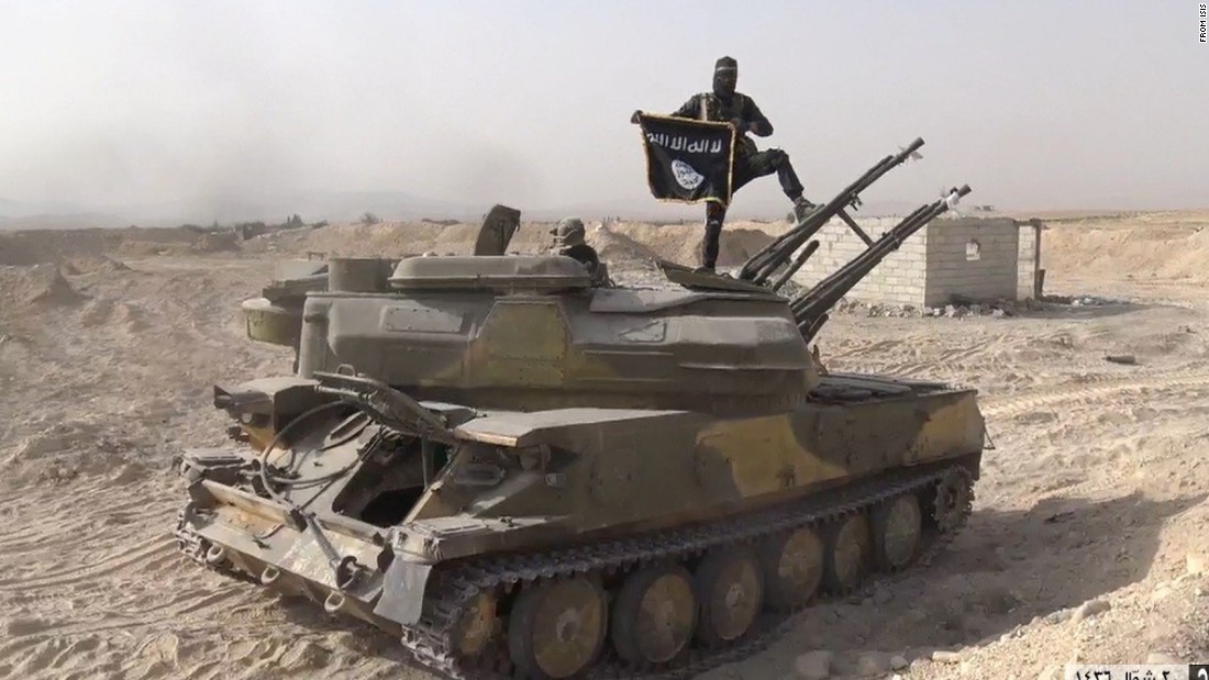 In this image taken from social media, an ISIS fighter holds the group&#39;s flag as he stands on a tank, purportedly captured when they took over the town of Qaryatain, Syria. ISIS, along with Boko Haram, is one of two groups accounting for 51% of claimed terrorism deaths in 2014. 