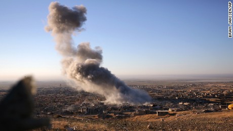 Smoke believed to be from an airstrike billows over the northern Iraqi town of Sinjar on Thursday, Nov. 12, 2015. Kurdish Iraqi fighters, backed by the U.S.-led air campaign, launched an assault Thursday aiming to retake the strategic town of Sinjar, which the Islamic State overran last year in an onslaught that caused the flight of tens of thousands of Yazidis and first prompted the U.S. to launch airstrikes against the militants. (AP Photo/Bram Janssen)