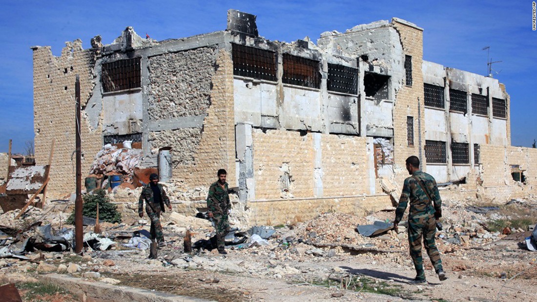 Syrian government troops walk inside the Kweiras air base on Wednesday, November 11, after they broke a siege imposed by ISIS militants.