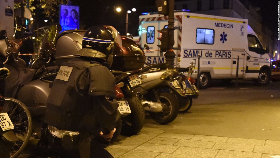 A riot police officer stands by an ambulance near the Bataclan concert hall in central Paris.