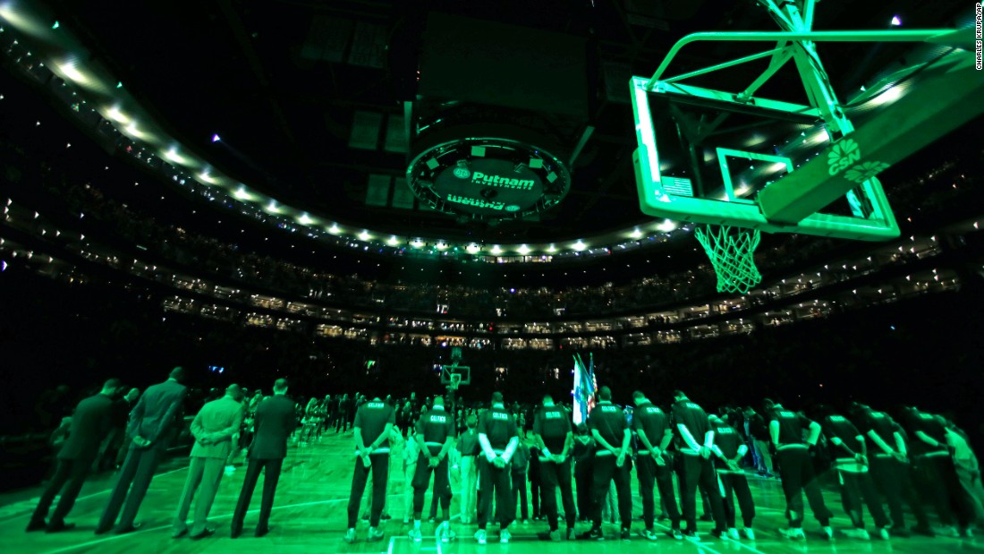 The house lights are shut off and scoreboard dark as Boston Celtics players pause for a moment of silence for the Paris victims before an NBA basketball game against the Atlanta Hawks in Boston on November 13.