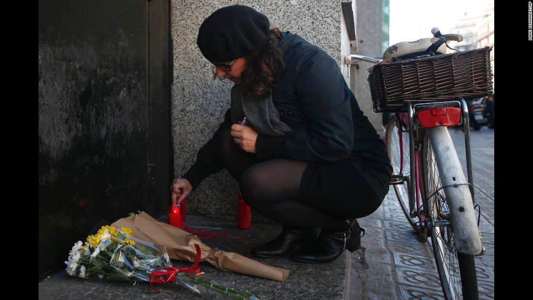 A woman lights a candle outside the French Consulate in Barcelona, Spain, on November 14.