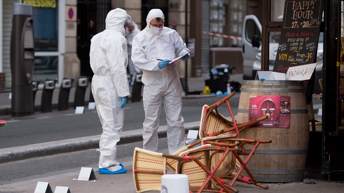 A forensic scientist works near a Paris cafe on Saturday, November 14, following a series of coordinated attacks in Paris the night before that killed scores of people. ISIS has claimed responsibility.