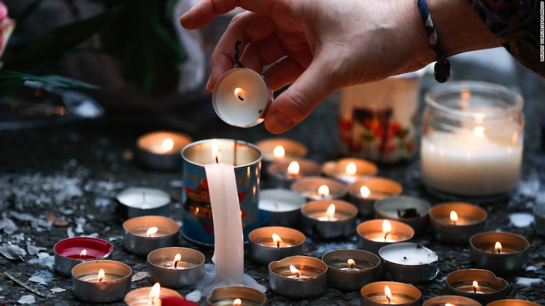 A woman lights candles at a memorial near the Bataclan theater in Paris on November 14.