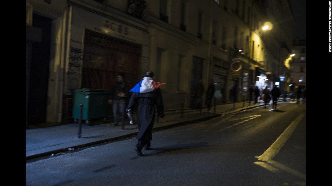 A man wearing a French flag walks through the streets of Paris on November 14. French President Francois Hollande has declared a state of emergency.