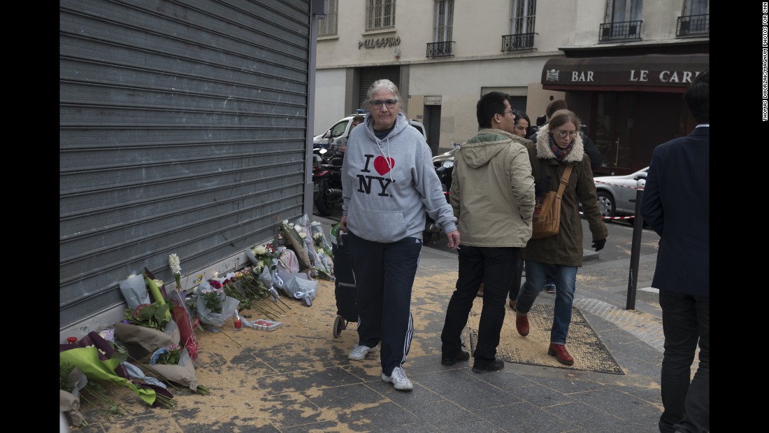 A woman walks past a memorial in Paris&#39; 10th district November 14.